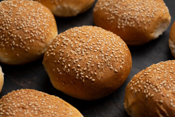 Burger bun bread with sesame seeds on dark background