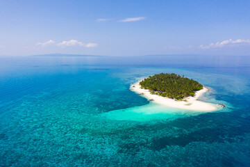 Island with a tropical beach and turquoise lagoons. Tropical island on a coral reef, top view.