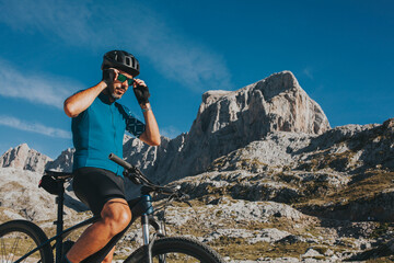 Male cyclist wearing sunglasses at Picos de Europa National Park on sunny day, Cantabria, Spain
