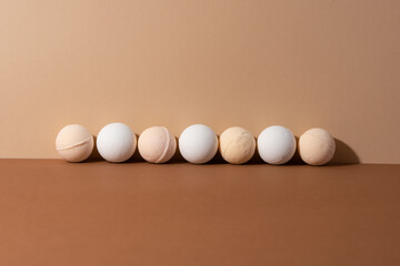 The organic bath bombs with shadow on beige background. Spa concept. Presents for body. Space for text.