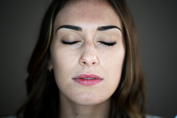 Young woman with eyes closed in studio