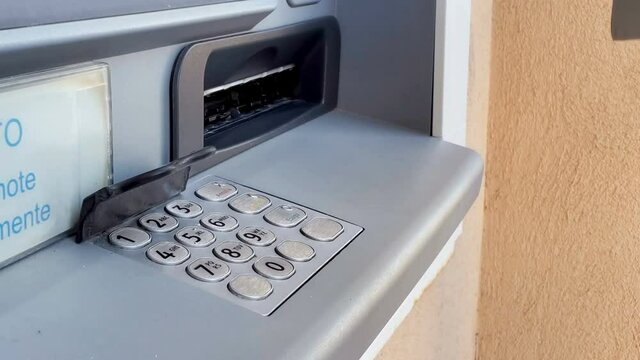 Woman withdrawing cash money banknotes from an atm bancomat machine,euro bills currency