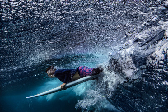 Male Surfer With Surfboard On Wave Undersea