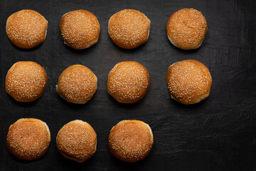 Burger bun bread with sesame seeds on dark background