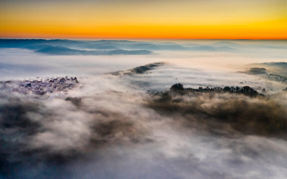 Germany, Baden-Wurttemberg, Berglen, Drone view of village shrouded in thick fog at dawn
