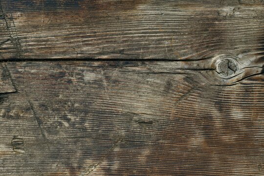 A wooden background from a one piece board with bitches and dents.
