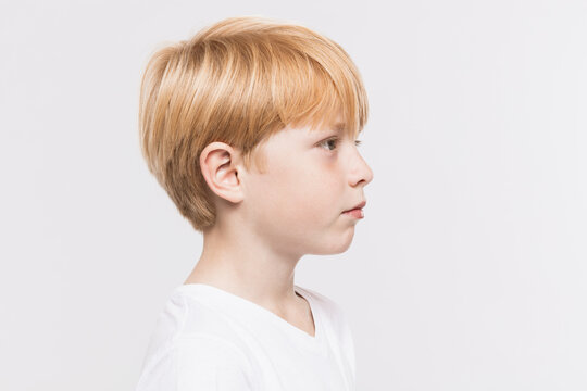 Thoughtful Boy With Blond Hair Against White Background