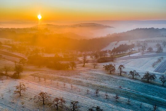 Germany, Baden-Wurttemberg, Berglen, Drone view of countryside fields at foggy autumn sunrise