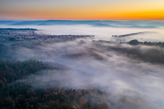 Germany, Baden-Wurttemberg, Berglen, Drone view of village shrouded in thick fog at dawn
