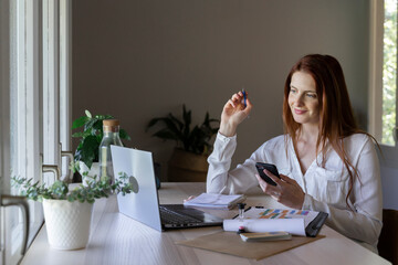 Smiling woman using mobile phone and fidget spinner while sitting at home