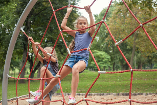 Girls climbing on jungle gym at playground