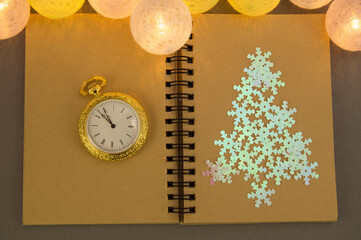 flat lay composition with diary book for writing down New Year's plans,christmas tree, clock and garland