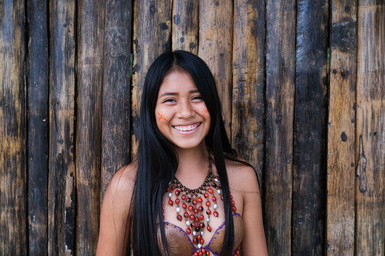 Happy young Guarani woman against bamboo wall, Misahualli, 
Ecuador