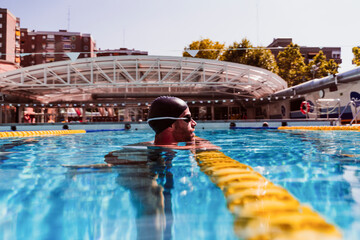 Male swimmer by lane marker in swimming pool
