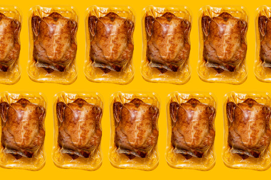 Vacuum packed roasted chickens on yellow background