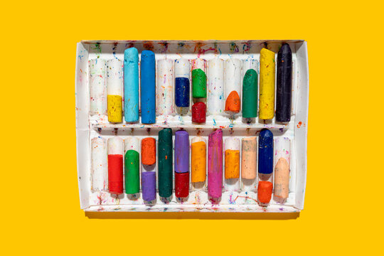 Colorful crayons on yellow background