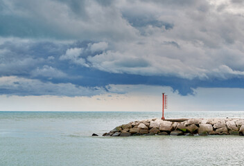 Red lighthouse in Caorle, estuary of Livenza river, in a cloudy day of September