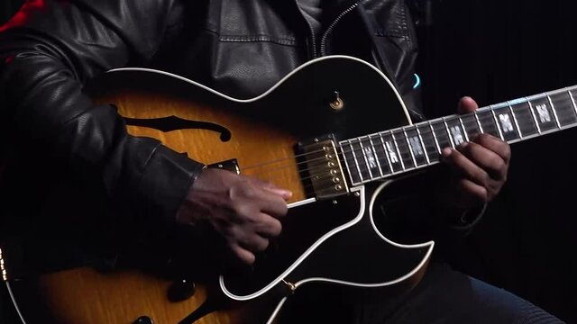 Close up Jazz guitar musician strumming strings  swaying to the music