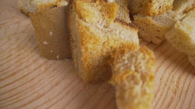 Croutons close-up. Slices of rusks on a white wooden background