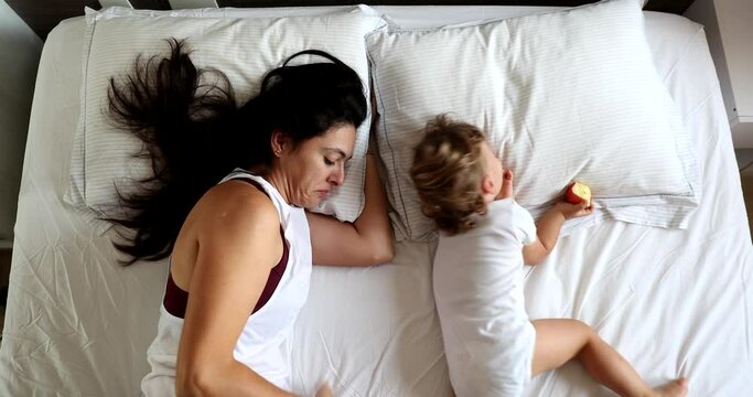 Happy Mother and baby son relationship in morning bed, top view