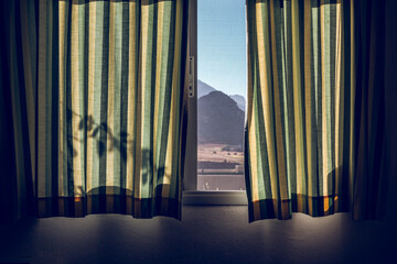Window covered by green striped curtains