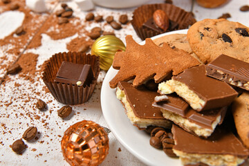 sweet food top view background for merry christmas or new year holiday decoration - chocolate candies, tangerines, cookies on white wood