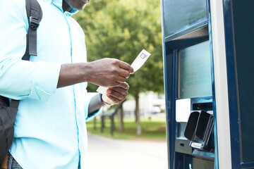 Mature male commuter checking bicycle sharing receipt by ticket machine