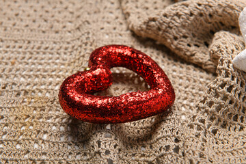 a red heart shape on wool textile background - new year or holiday decoration