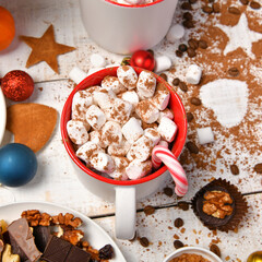 sweet food top view background for merry christmas or new year holiday decoration - chocolate candies, tangerines, cookies, marshmallow and cocoa latte on white wood