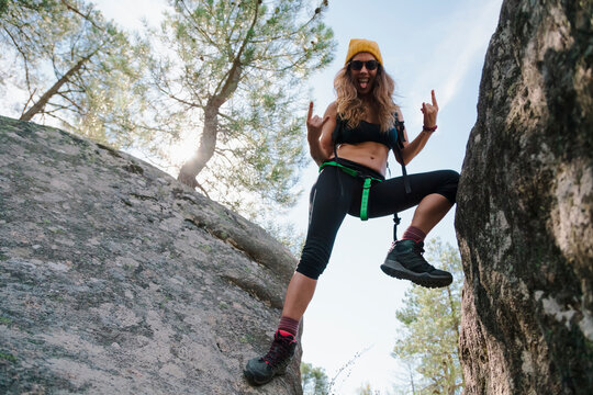 Carefree woman gesturing while balancing on rock in forest at La Pedriza, Madrid, Spain