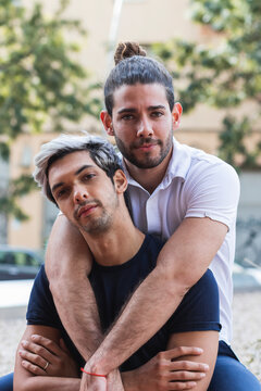 Confident man with male partner sitting in city