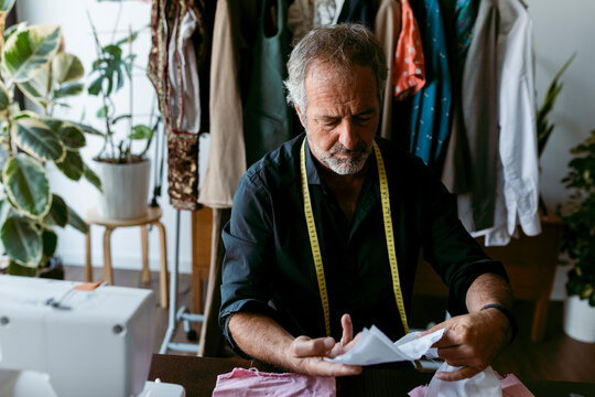 Tailor checking fabric swatch at work studio
