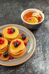 Vertical view of fruit pancakes with lemon tea stock image