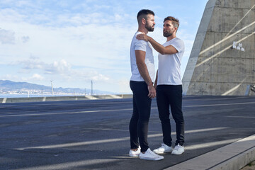 Gay couple standing at Parc del Forum against sky, Barcelona, Spain