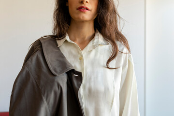Fashionable woman wearing retro style clothes standing against wall