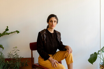 Beautiful female model sitting on chair at home