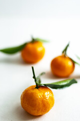 Three ripe tangerines with leaves close-up on a light background. Copy space.