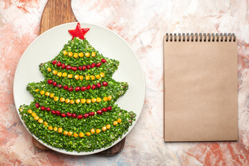 top view tasty green salad in new year tree shape inside plate with notepad on light background meal photo xmas holiday color