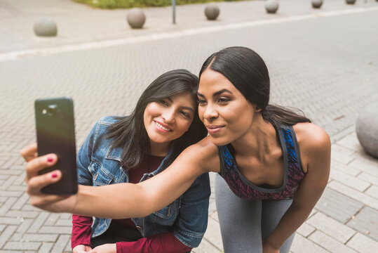 Young woman taking selfie with female friend