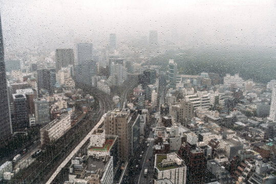 Japan, Tokyo, Downtown buildings on rainy day seen from window