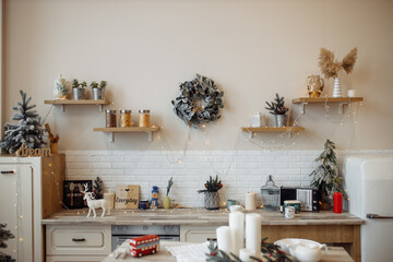 Obraz na płótnie Canvas Comfort cozy kitchen interior with cristmas tree lights candles wreaths wooden shelves