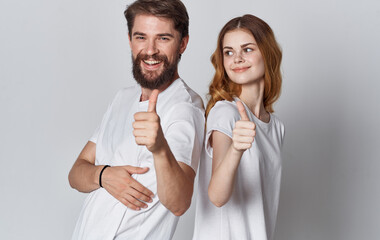 A man and a woman in jeans and a T-shirt are gesturing with their hands fun emotions Copy Space