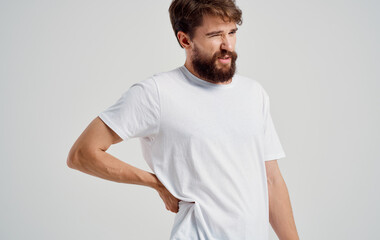 back pain young man in t-shirt beard mustache brunette