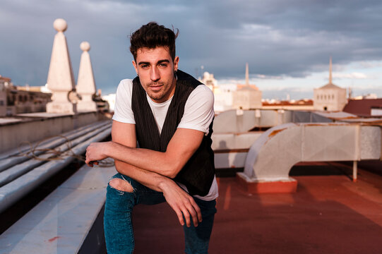 Portrait of a handsome man in the rooftop of a building at sunset