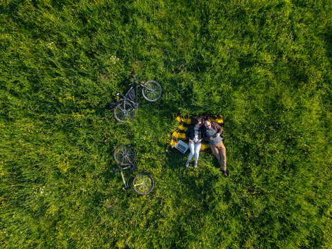 Couple lying on grass, aerial view
