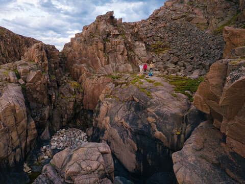 Russia, Murmansk region,&not;&dagger;Kolsky&not;&dagger;District, Teriberka, People walking&not;&dagger;on&not;&dagger;rocky coast, aerial view
