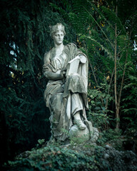 Obraz premium Statue of a woman in a green park