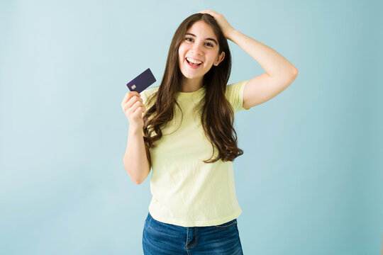 Portrait Of An Excited Young Woman Holding Up Her Credit Card