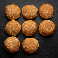 Burger bun bread with sesame seeds on dark background