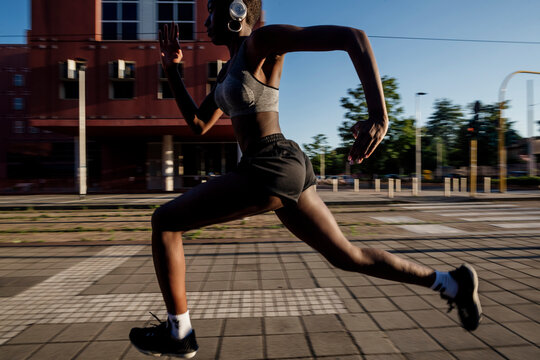 Female athlete running on street in city